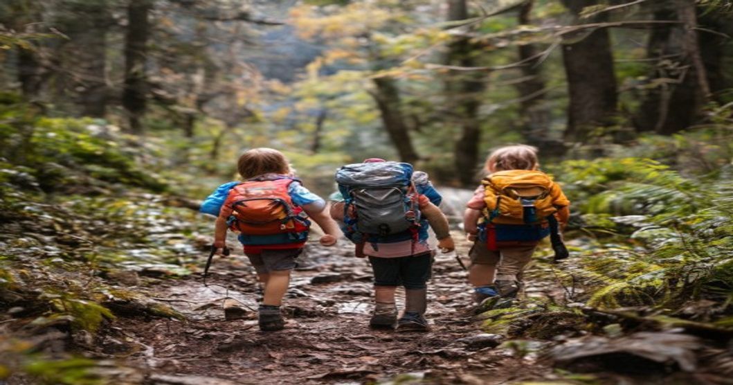 Niños bebiendo agua en fuente de montaña durante ruta de senderismo familiar en bosque español